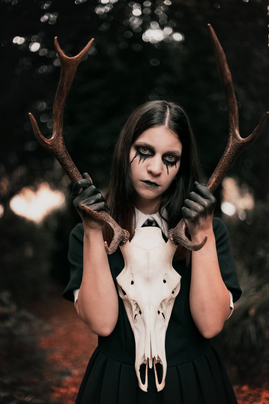 photo of woman holding antler